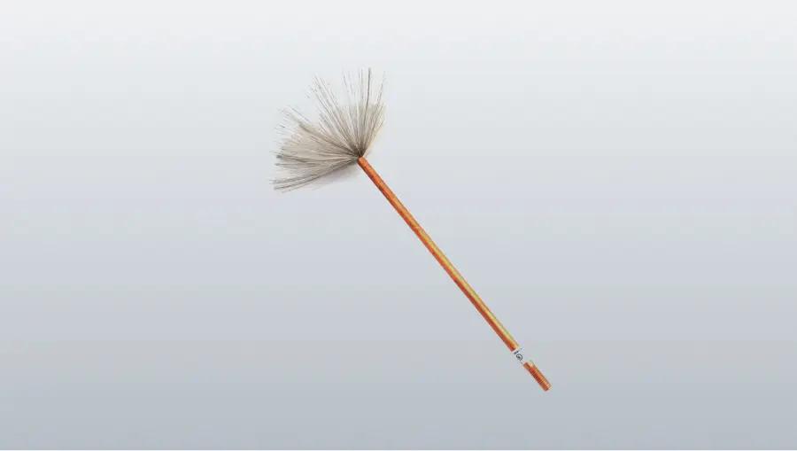 A long wooden-handled brush with soft gray bristles lies diagonally on a plain white background.