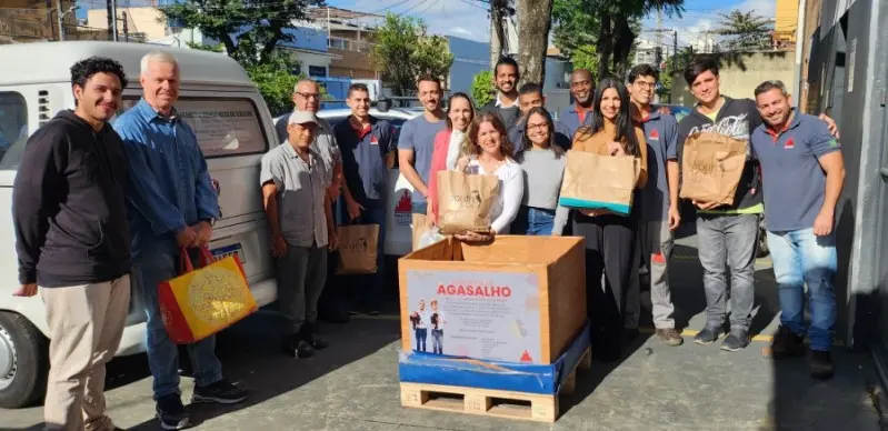Un grupo de personas de todo tipo con una caja de leña delante