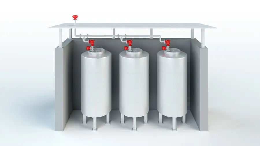 Eine 3D-Darstellung zeigt drei vertikale Lagertanks unter einem Dach, die durch Rohrleitungen verbunden sind, auf deren Oberseite sich rote Sicherheitsventile befinden.